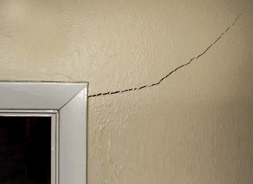 Corner cracks above door frame in home
